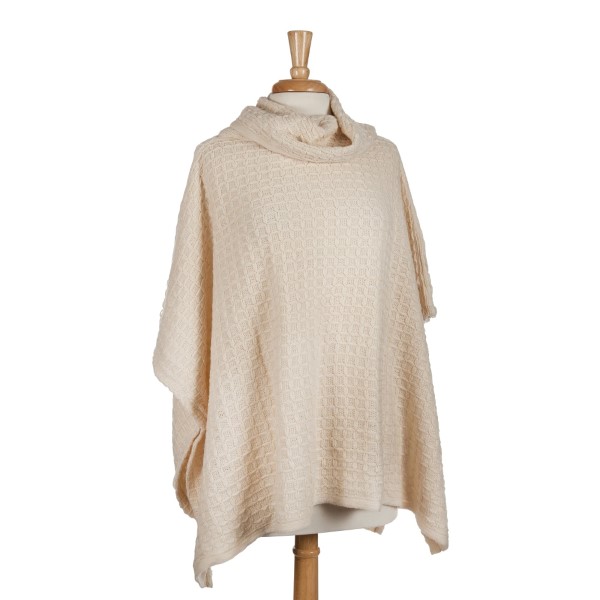 Ivory short sleeve, turtle neck poncho top with a cable knit pattern. 100% acrylic. One size fits most. 