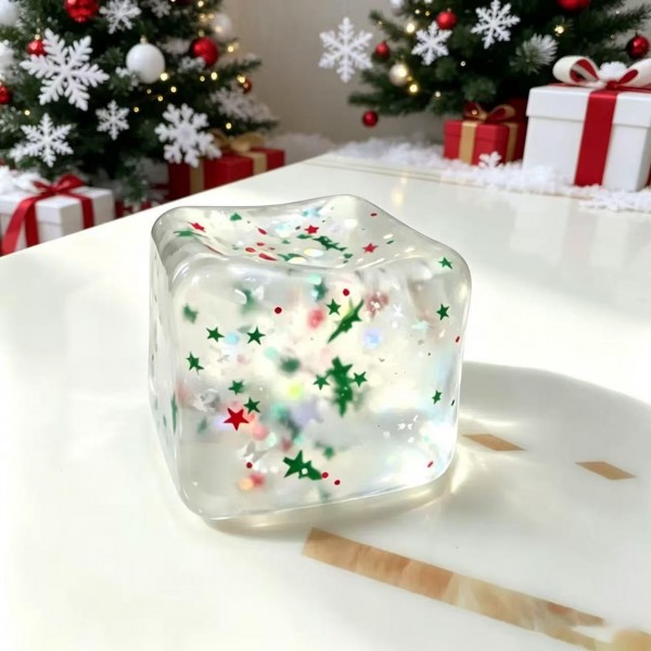 Confetti cube squishy filled with tiny holiday flecks suspended in a clear jelly block that catches the light from every angle. The soft body flattens under a squeeze and drifts back into a cube shape. A quiet fidget that looks like decor when it is sitting out on a desk or a shelf. Seasonal sparkle at an impulse price point.