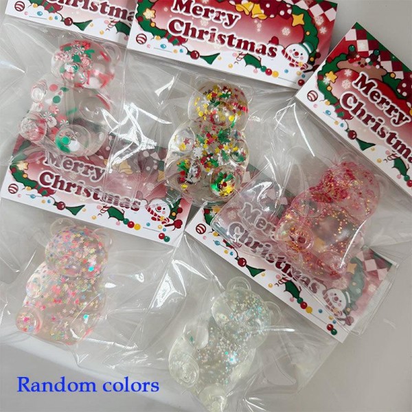 Glitter-filled bear squishy on a printed holiday header card, with confetti sparkle suspended in a soft, squeezable body. The card hangs on a peg or stands in a bowl and doubles as gift packaging, so it needs no extra wrap at the register. Ships in a random color mix, which fills a display with variety off a single order. An easy stocking-stuffer and class-gift add-on at an impulse price.