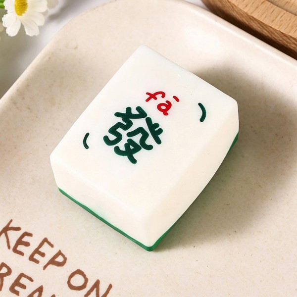 Mahjong tile squishy molded as a full size game tile with a raised painted character and a colored base edge. Slow rise foam compresses under a squeeze and slowly returns to shape for repeat fidgeting. A counter impulse toy for boutiques stocking game night gifts, classroom rewards, desk toys, and stocking stuffers. Game tile squishies pull a second look on a display riser and ring up as an easy add on.