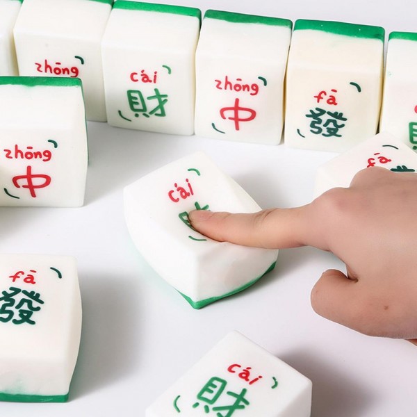 Mahjong tile squishy molded as a full size game tile with a raised painted character and a colored base edge. Slow rise foam compresses under a squeeze and slowly returns to shape for repeat fidgeting. A counter impulse toy for boutiques stocking game night gifts, classroom rewards, desk toys, and stocking stuffers. Game tile squishies pull a second look on a display riser and ring up as an easy add on.