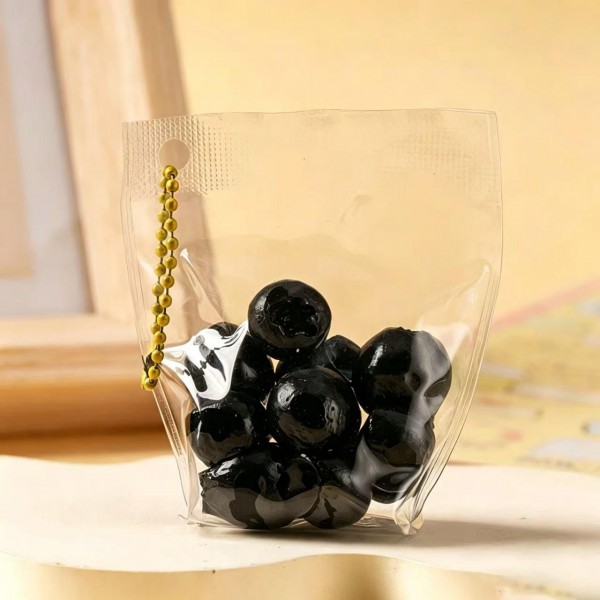 Fruit squishy key ring packed in a clear pouch with a beaded chain, ready to clip onto a backpack, a purse strap, or a set of keys. Each piece is molded and painted to look like fresh cut fruit, with a soft slow rise squeeze that rebounds after every press. A tiny stress reliever that doubles as a bag charm, which is exactly why they disappear off a counter display. Ideal for teen gifting, party favors, and impulse racks.
