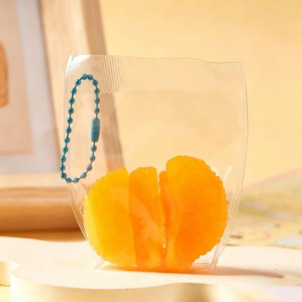 Fruit squishy key ring packed in a clear pouch with a beaded chain, ready to clip onto a backpack, a purse strap, or a set of keys. Each piece is molded and painted to look like fresh cut fruit, with a soft slow rise squeeze that rebounds after every press. A tiny stress reliever that doubles as a bag charm, which is exactly why they disappear off a counter display. Ideal for teen gifting, party favors, and impulse racks.