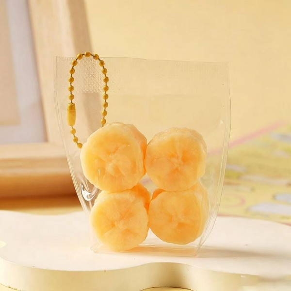 Fruit squishy key ring packed in a clear pouch with a beaded chain, ready to clip onto a backpack, a purse strap, or a set of keys. Each piece is molded and painted to look like fresh cut fruit, with a soft slow rise squeeze that rebounds after every press. A tiny stress reliever that doubles as a bag charm, which is exactly why they disappear off a counter display. Ideal for teen gifting, party favors, and impulse racks.