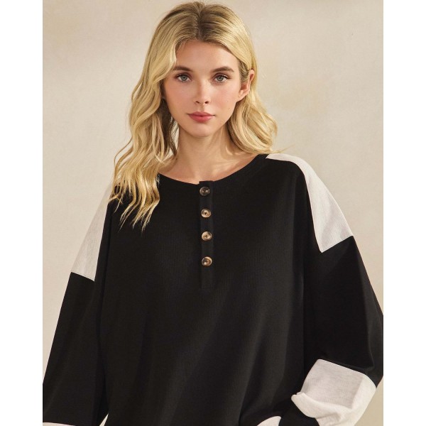 Color block waffle knit henley top with a buttoned placket and a relaxed drop-shoulder silhouette. Soft ribbed-texture knit gives the oversized cut structure, while contrast panels at the shoulders and cuffs add visual interest to an everyday staple. Easy to layer over leggings, denim, or bike shorts for weekend errands, school pickup, and cozy fall weather. A transitional long sleeve top that turns fast for boutiques building comfortable seasonal assortments.