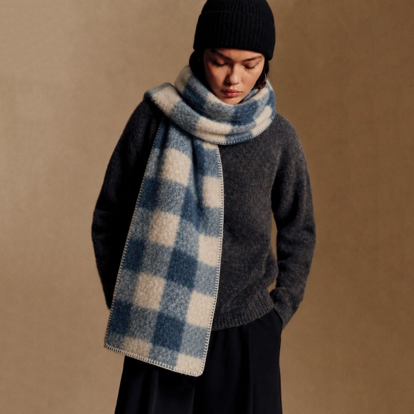 Buffalo check blanket scarf in a brushed soft finish with a long, generous drape. Big enough to wrap, loop, or wear open as a shoulder layer over outerwear. The oversized check is a cold weather classic that customers look for by name every fall. It stocks well as a gift item and pairs naturally with beanies and gloves on the same display.