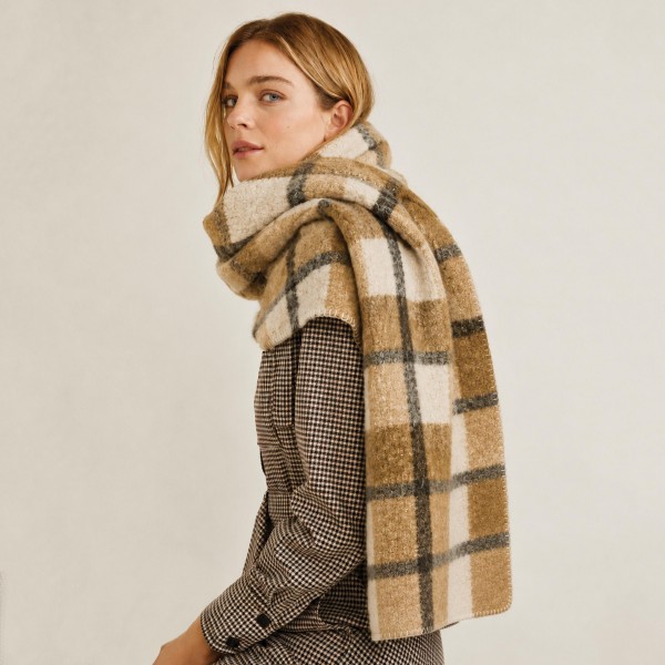Oversized brushed plaid scarf with a soft napped face and a generous rectangular cut. Wide enough to wrap twice at the neck or drape open over a coat, and warm without feeling stiff. The classic check reads timeless against wool coats, denim, and knitwear. Blanket scarves are a proven cold weather driver and an easy gift grab.