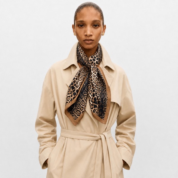 Leopard print bandana scarf cut as a generous square in a lightweight woven fabric. Tie it at the throat over a coat collar, knot it on a tote, or fold it into a hair wrap. The classic spotted repeat works across seasons and pairs with the neutrals shoppers already own. A proven print that moves fast in a counter display.