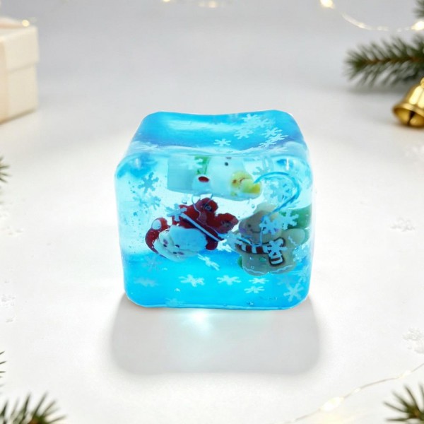 Christmas Jelly Cube Squishy

Christmas Jelly Cube Squishy shaped like a glossy ice cube with festive charms floating inside, including gingerbread men, snowmen, mittens, and snowflake confetti. The clear, rubbery shell is filled with a thick, gooey jelly that gives a slow, dense squeeze, then gradually settles back into a perfect cube. It feels smooth and cool in the hand and looks like a mini holiday snow globe sitting on a desk. Ice cube squishies are one of the hottest textures right now, and this Christmas version is a natural stocking stuffer.

- Holiday charms sealed inside the clear cube