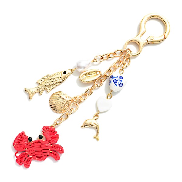 Gold Tone Bag Charm Featuring Sea Charms, Raffia, And Chinoiserie Beads 

- Approximately 5.5" L 
