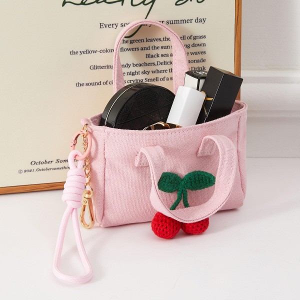 A sweet structured mini handbag accented with a decorative cherry charm for an extra dose of whimsy. The compact boxy design pairs top handles with a removable wrist strap for versatile everyday carry. This fruit-themed accessory taps into a perennially popular motif — ideal for boutiques capitalizing on cherry and fruit-print trend momentum. A charming impulse buy that appeals to shoppers who love feminine novelty accessories with standout detail.