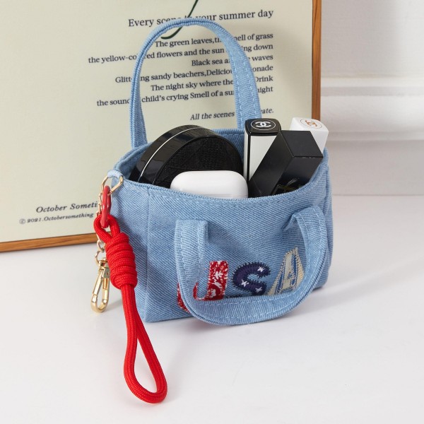 A compact structured mini handbag in denim fabric featuring bold 'USA' embroidery in patriotic lettering, with a removable wrist strap for versatile everyday styling. The boxy silhouette and strong graphic design make this an ideal seasonal accessory for summer holidays. Boutique-friendly and easy to merchandise, it pairs naturally with Americana-themed apparel and accessories. A proven impulse buy that performs consistently during Fourth of July and Memorial Day selling windows.
