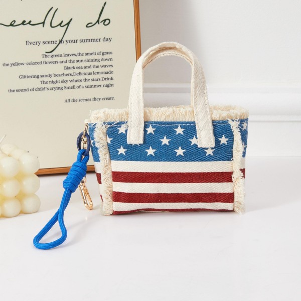 A compact structured mini handbag featuring bold all-over American flag print with top handles and a removable wrist strap for versatile carry options. The boxy, fashion-forward silhouette and patriotic design make it a standout accessory for summer holiday celebrations and everyday statement styling. A must-have seasonal piece for boutiques building Fourth of July and Americana collections. Merchandise near patriotic apparel or accessories for a cohesive display that drives impulse purchases.