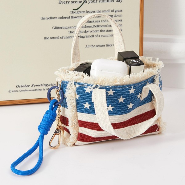 A compact structured mini handbag featuring bold all-over American flag print with top handles and a removable wrist strap for versatile carry options. The boxy, fashion-forward silhouette and patriotic design make it a standout accessory for summer holiday celebrations and everyday statement styling. A must-have seasonal piece for boutiques building Fourth of July and Americana collections. Merchandise near patriotic apparel or accessories for a cohesive display that drives impulse purchases.