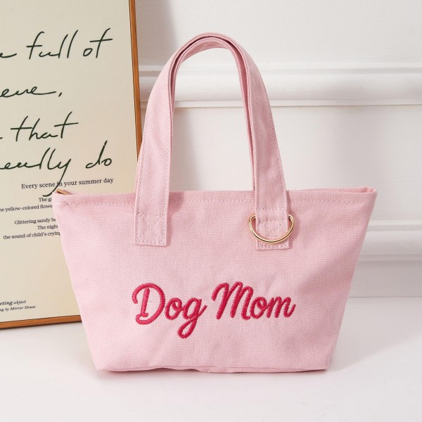 A playful 'Dog Mom' embroidered mini tote that resonates instantly with pet-loving shoppers. Crafted from soft terry fabric with sturdy top handles and a gold-tone accent, this compact carryall combines everyday charm with boutique-ready appeal. Perfect for dog owners who wear their affection as a fashion statement. Easy to display and quick to sell, this novelty tote is a reliable impulse buy and gift item that drives repeat traffic to your accessories floor.