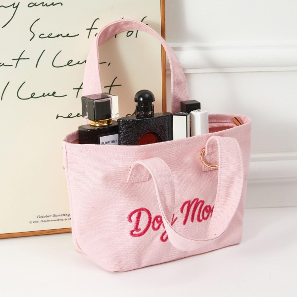 A playful 'Dog Mom' embroidered mini tote that resonates instantly with pet-loving shoppers. Crafted from soft terry fabric with sturdy top handles and a gold-tone accent, this compact carryall combines everyday charm with boutique-ready appeal. Perfect for dog owners who wear their affection as a fashion statement. Easy to display and quick to sell, this novelty tote is a reliable impulse buy and gift item that drives repeat traffic to your accessories floor.