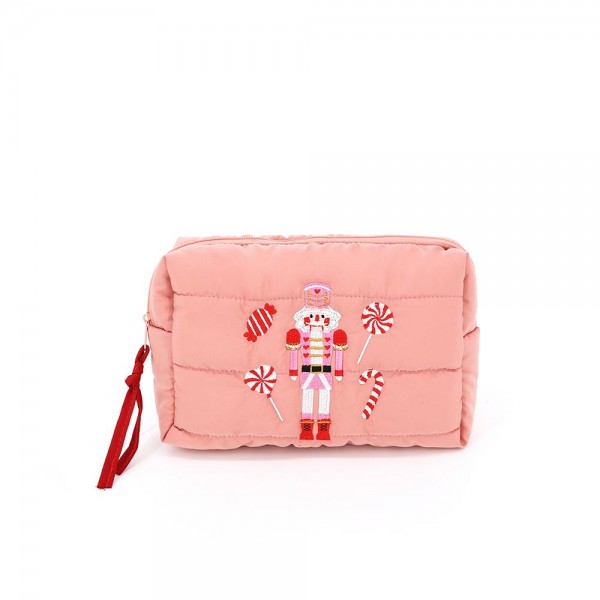 Quilted puffer bag with a padded body and an embroidered nutcracker and peppermint design. Sold as a padded tote and a matching zip pouch so she can carry the big one and keep the small one in it. A seasonal carry for boutique buyers stocking hostess gifts, teacher gifts, cookie exchanges, and holiday markets. Puffy quilted bags are light, wipe clean, and ring up as the easy grab and go gift all December.