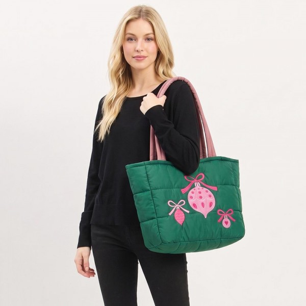Quilted puffer bag with a padded body and embroidered hanging ornaments on the front. Sold as a padded tote and a matching zip pouch so she can carry the big one and keep the small one in it. A seasonal carry for boutique buyers stocking hostess gifts, teacher gifts, cookie exchanges, and holiday markets. Puffy quilted bags are light, wipe clean, and ring up as the easy grab and go gift all December.