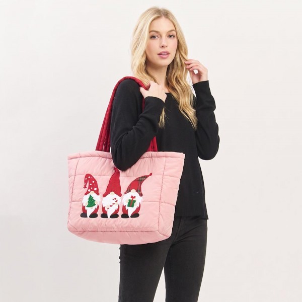 Quilted puffer bag with a padded body and an embroidered gnome trio across the front. Sold as a padded tote and a matching zip pouch so she can carry the big one and keep the small one in it. A seasonal carry for boutique buyers stocking hostess gifts, teacher gifts, cookie exchanges, and holiday markets. Puffy quilted bags are light, wipe clean, and ring up as the easy grab and go gift all December.