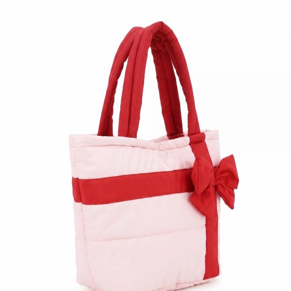 Quilted puffer bag styled like a wrapped present, with a contrast ribbon band and an oversized bow. Sold as a padded tote and a matching zip pouch so she can carry the big one and keep the small one in it. A seasonal carry for boutique buyers stocking hostess gifts, teacher gifts, cookie exchanges, and holiday markets. Puffy quilted bags are light, wipe clean, and ring up as the easy grab and go gift all December.