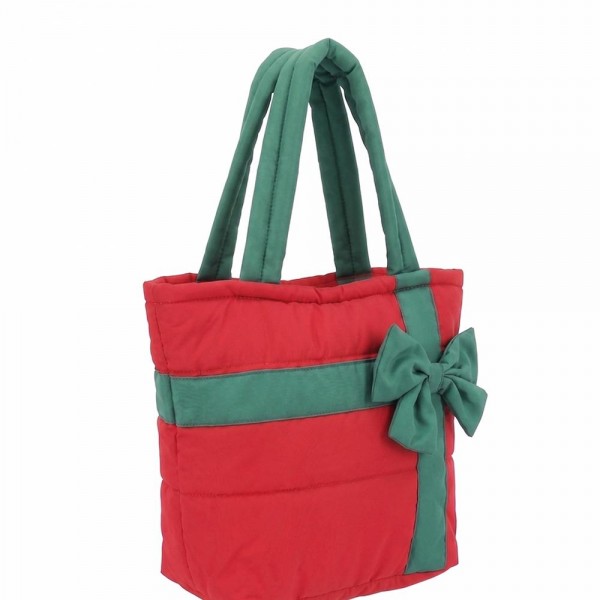 Quilted puffer bag styled like a wrapped present, with a contrast ribbon band and an oversized bow. Sold as a padded tote and a matching zip pouch so she can carry the big one and keep the small one in it. A seasonal carry for boutique buyers stocking hostess gifts, teacher gifts, cookie exchanges, and holiday markets. Puffy quilted bags are light, wipe clean, and ring up as the easy grab and go gift all December.