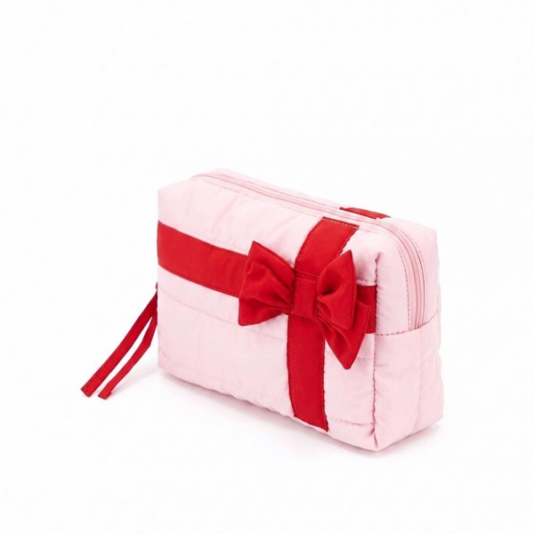Quilted puffer bag styled like a wrapped present, with a contrast ribbon band and an oversized bow. Sold as a padded tote and a matching zip pouch so she can carry the big one and keep the small one in it. A seasonal carry for boutique buyers stocking hostess gifts, teacher gifts, cookie exchanges, and holiday markets. Puffy quilted bags are light, wipe clean, and ring up as the easy grab and go gift all December.