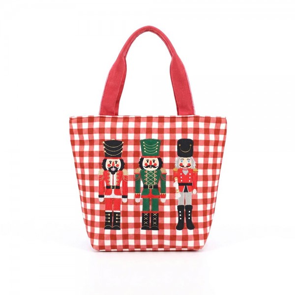Gingham canvas tote with an embroidered nutcracker trio and contrast webbing handles. Roomy open top carries a wrapped gift, a bottle of wine, or a stack of cookies to the party, and the flat base keeps it upright on a counter. A seasonal carry for boutique buyers stocking hostess gifts, teacher gifts, cookie exchanges, and holiday markets. Embroidered gingham totes double as the gift and the wrapping, which is why they sell out every December.