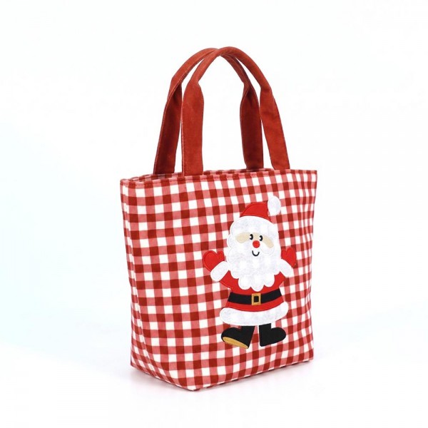 Gingham canvas tote with an embroidered santa applique and contrast webbing handles. Roomy open top carries a wrapped gift, a bottle of wine, or a stack of cookies to the party, and the flat base keeps it upright on a counter. A seasonal carry for boutique buyers stocking hostess gifts, teacher gifts, cookie exchanges, and holiday markets. Embroidered gingham totes double as the gift and the wrapping, which is why they sell out every December.