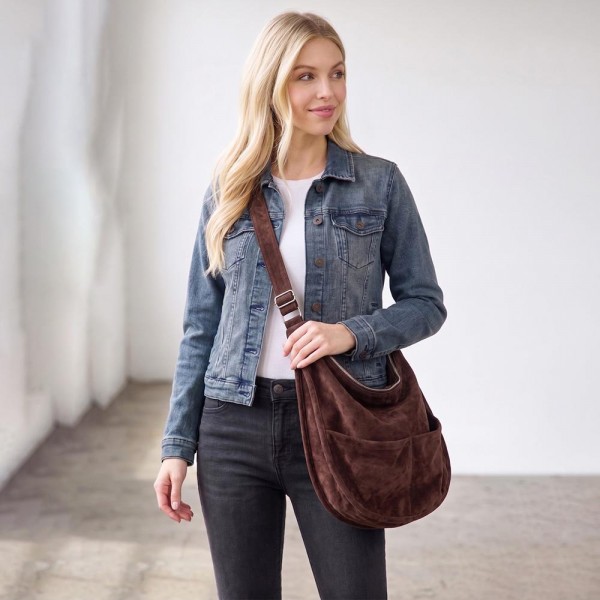 Slouchy suede hobo bag with a wide adjustable strap and a soft unstructured body. Roomy main compartment swallows a wallet, sunglasses, and a water bottle, and the pillow soft body sits close without pulling at the shoulder. An everyday carry for boutique buyers stocking travel, campus, farmers markets, and weekend errands. Soft hobo bags are the shape customers come back for, and the neutral run sells across every outfit.