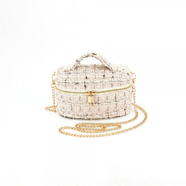 Tweed vanity box bag with a gold tone chain strap, top zip closure, and a knotted top handle. Structured oval shape holds its form on a shelf and opens flat for a phone, cards, and a lipstick. A dressed up piece for boutique buyers stocking holiday parties, weddings, showers, and gallery nights. Structured tweed bags photograph beautifully and sell as the gift a customer keeps for herself.