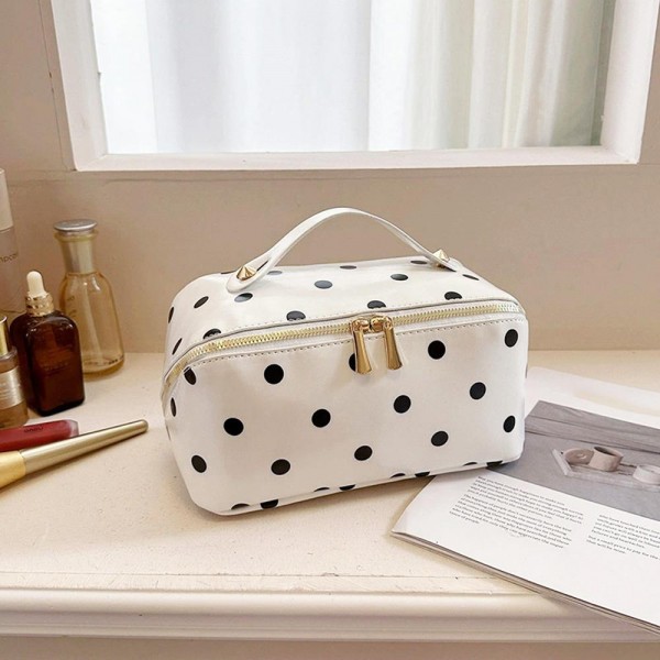 Wide opening makeup case that unzips almost fully so everything lies flat and visible instead of buried at the bottom. A padded body protects glass bottles and pressed compacts, and the short top handle makes it easy to move from counter to suitcase. The coated polka dot exterior wipes clean with a damp cloth. An everyday travel piece priced for repeat purchase and easy gifting.