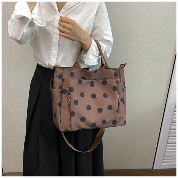 Polka Dot Nylon Crossbody Tote with dual top handles, an adjustable shoulder strap, and plenty of exterior pockets for a phone, water bottle, and keys. The lightweight fabric and roomy interior make it a smart pick for travel days, sports practice, errands, and diaper bag duty. Carry it by hand or wear it crossbody when you need to stay hands free. A practical, playful bag that busy moms and teachers love, priced to move quickly.