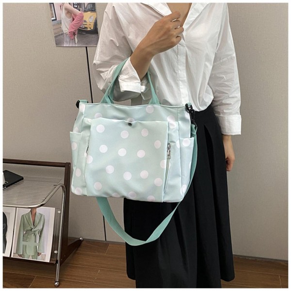 Polka Dot Nylon Crossbody Tote with dual top handles, an adjustable shoulder strap, and plenty of exterior pockets for a phone, water bottle, and keys. The lightweight fabric and roomy interior make it a smart pick for travel days, sports practice, errands, and diaper bag duty. Carry it by hand or wear it crossbody when you need to stay hands free. A practical, playful bag that busy moms and teachers love, priced to move quickly.