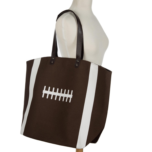 Football tote bag perfect for tailgating and monogramming. This bag features a snap closure, lined interior and interior pockets. 16" x 19" in size with a 10" handle drop. 80% cotton and 20% polyester. 