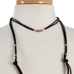 Black suede wrap necklace with gold tone hardware. Approximately 32" in length. 