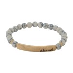 Beaded stretch bracelet with a bar focal, stamped with "blessed."