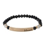 Beaded stretch bracelet with a bar focal, stamped with "blessed."