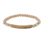 Beaded stretch bracelet with a bar focal, stamped with "blessed."