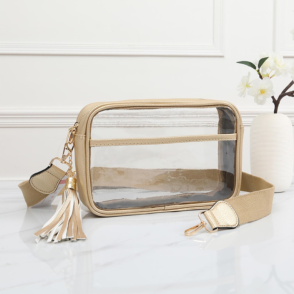 Clear PU Cross Body Bag With Leather Walls and Trim Featuring Detachable Leather Tassel - Zip Closure - One Outer Open Pocket - Detachable Canvas Strap - Approximately 6.5" T x 10" L x 2.5" W - Strap Drop 15" - 24" L view 2