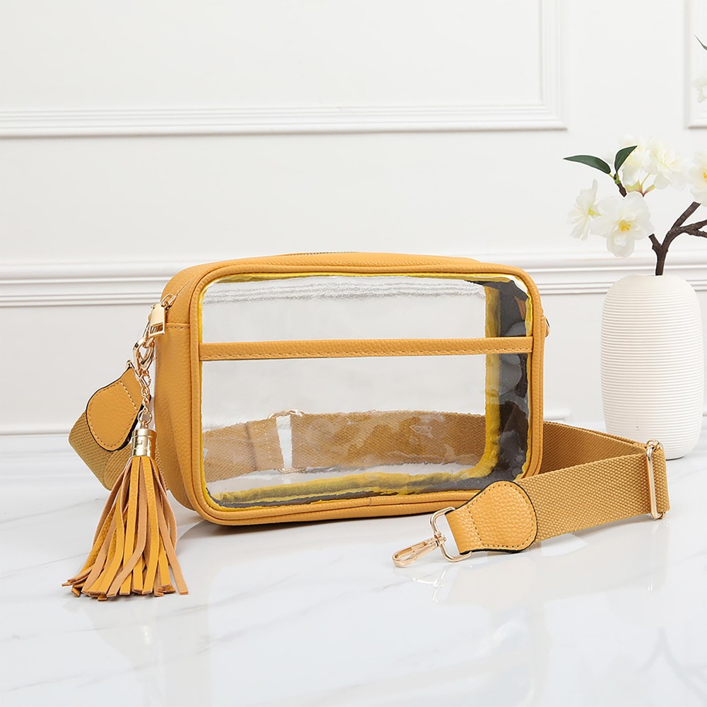 Clear PU Cross Body Bag With Leather Walls and Trim Featuring Detachable Leather Tassel - Zip Closure - One Outer Open Pocket - Detachable Canvas Strap - Approximately 6.5" T x 10" L x 2.5" W - Strap Drop 15" - 24" L view 2