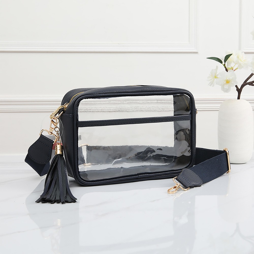 Clear PU Cross Body Bag With Leather Walls and Trim Featuring Detachable Leather Tassel - Zip Closure - One Outer Open Pocket - Detachable Canvas Strap - Approximately 6.5" T x 10" L x 2.5" W - Strap Drop 15" - 24" L view 2