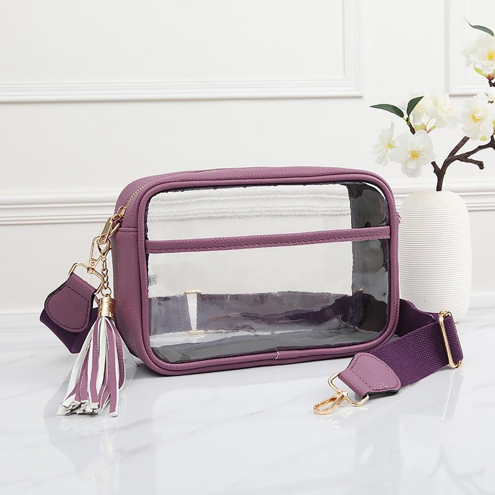 Clear PU Cross Body Bag With Leather Walls and Trim Featuring Detachable Leather Tassel - Zip Closure - One Outer Open Pocket - Detachable Canvas Strap - Approximately 6.5" T x 10" L x 2.5" W - Strap Drop 15" - 24" L view 2