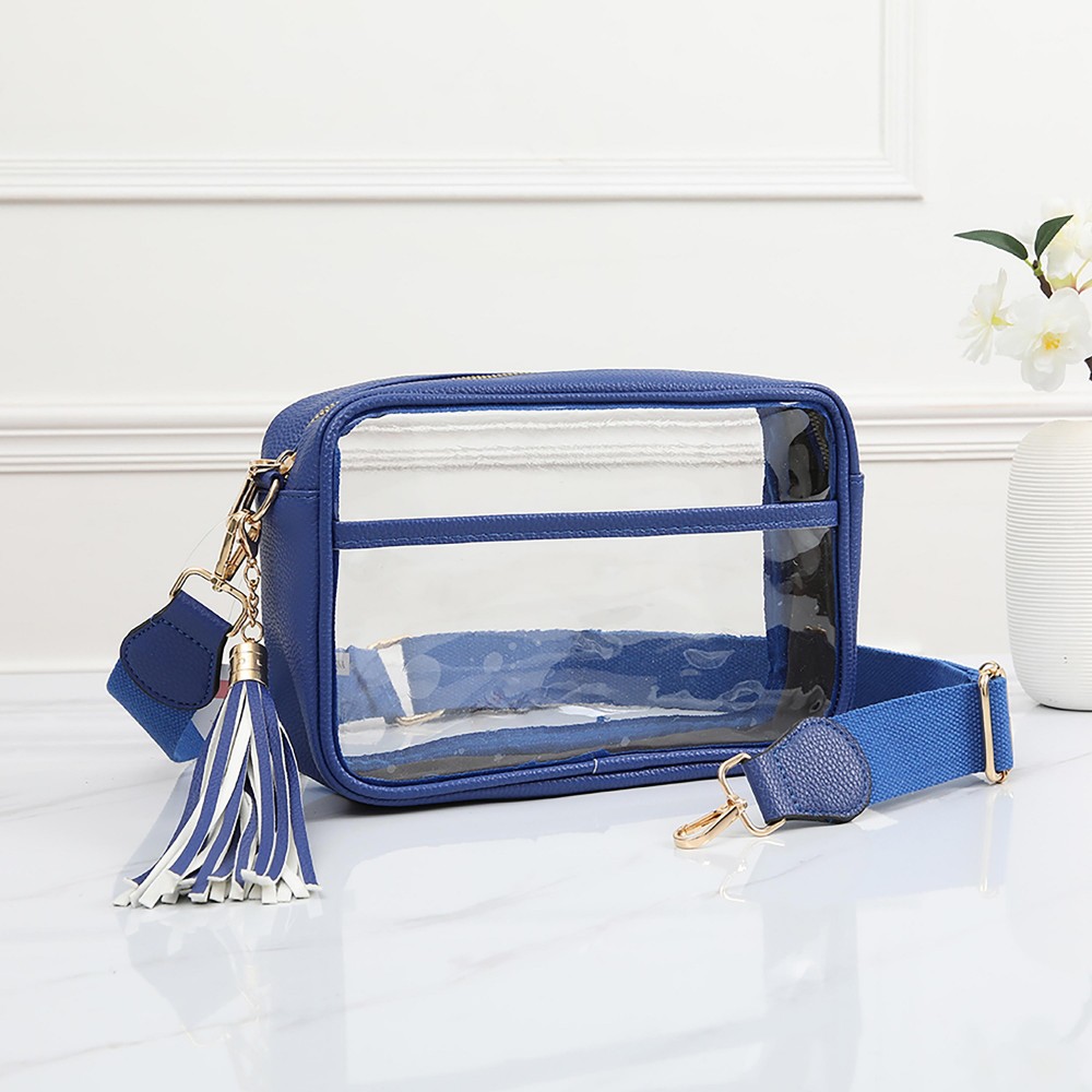 Clear PU Cross Body Bag With Leather Walls and Trim Featuring Detachable Leather Tassel - Zip Closure - One Outer Open Pocket - Detachable Canvas Strap - Approximately 6.5" T x 10" L x 2.5" W - Strap Drop 15" - 24" L view 2