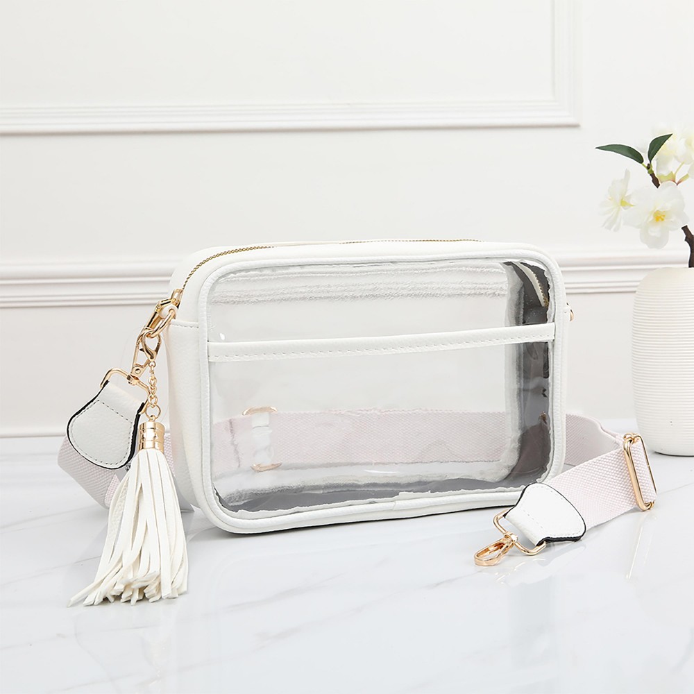 Clear PU Cross Body Bag With Leather Walls and Trim Featuring Detachable Leather Tassel - Zip Closure - One Outer Open Pocket - Detachable Canvas Strap - Approximately 6.5" T x 10" L x 2.5" W - Strap Drop 15" - 24" L view 2
